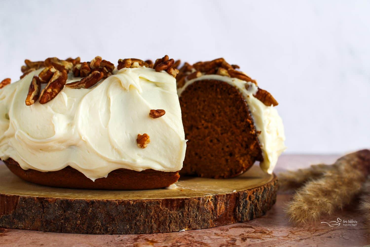 Pumpkin Bundt Cake with Cream Cheese Frosting (Cinderella Cake) on a wooden serving plate