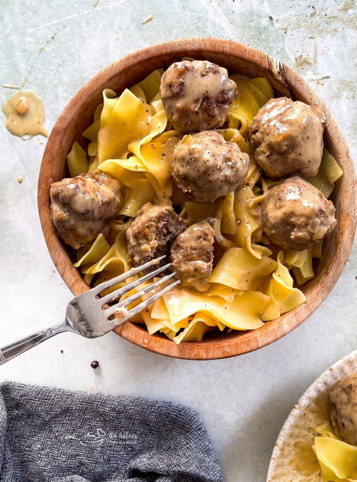 Swedish meatballs and egg noodles in a wooden bowl, up close
