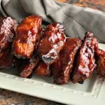 Close up of Slow Cooker Dr. Pepper BBQ Ribs on a white serving plate