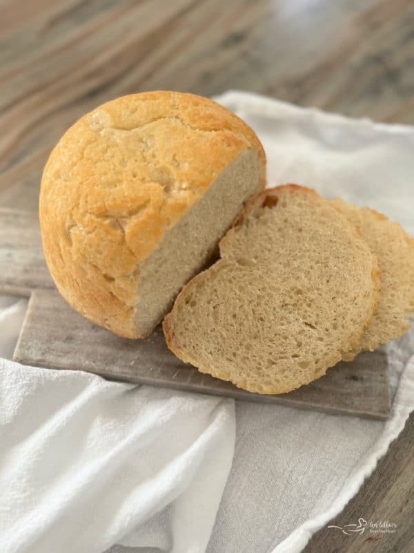 one loaf of peasant bread on cutting board with slices