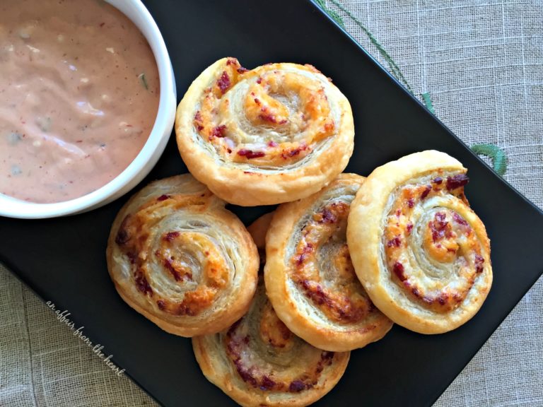 Reuben Pinwheels with thousand island dressing on a black serving plate