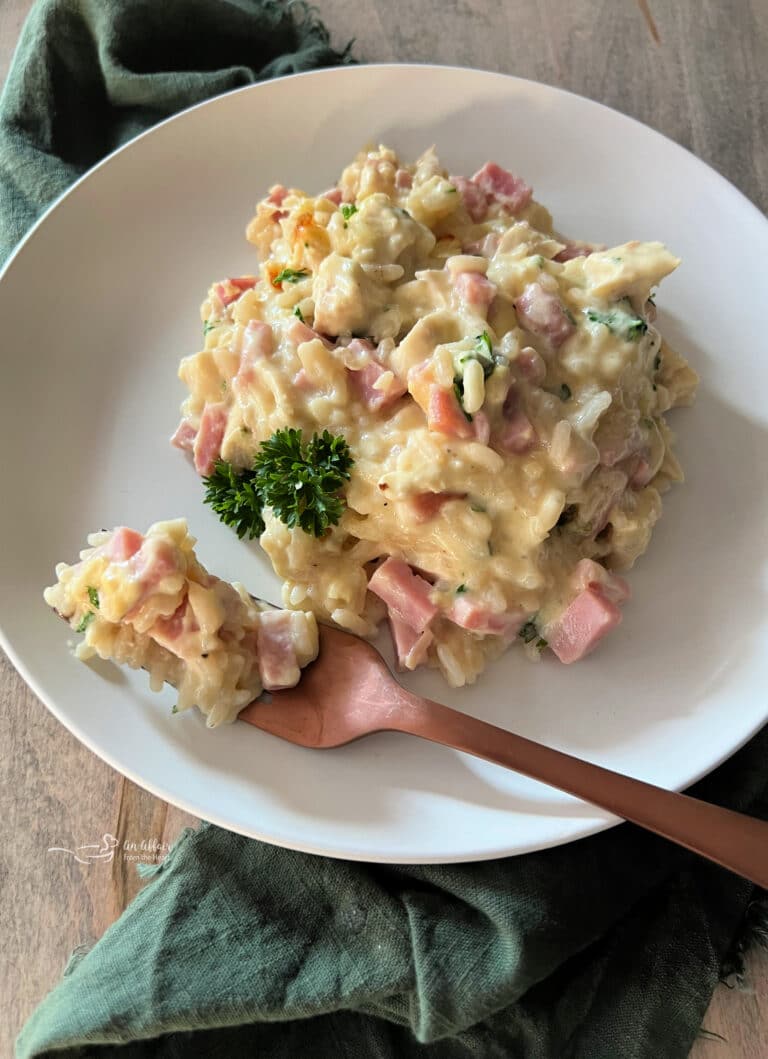 Chicken Cordon Bleu Casserole with Rice and a fork on a white plate.