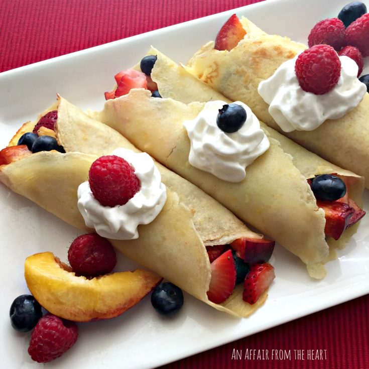 Close up of Sweet Crepes with Summer Fruits ona white serving plate