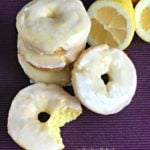Close up of Baked Glazed Lemon Donuts and one with a bite out of it