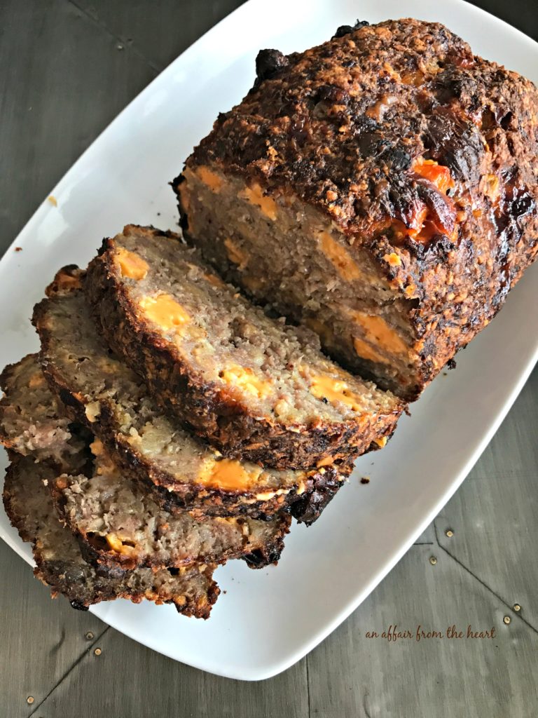 Overhead of Pork Sausage Meatloaf sliced on a white serving platter