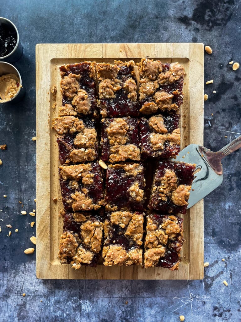 PB&J Oatmeal Cookie Bars cut into squares on a wooden board