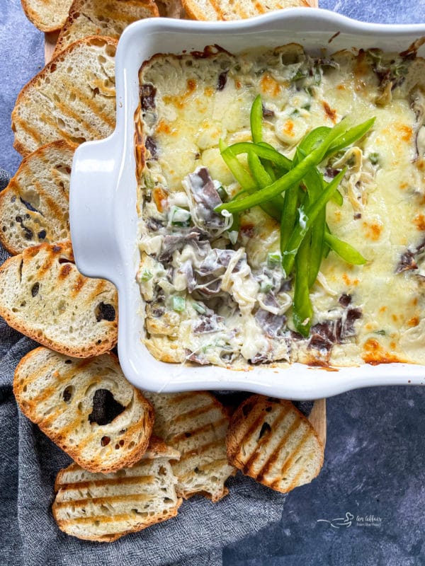 philly cheese steak dip in baking dish with green peppers