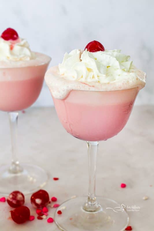 Whip cream and cherry topped pink squirrel cocktail.