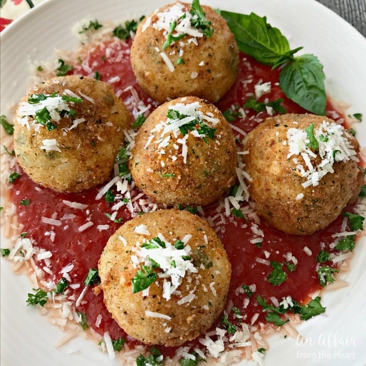 Close up of Arancini - Three Cheese Fried Risotto Balls on a white plate