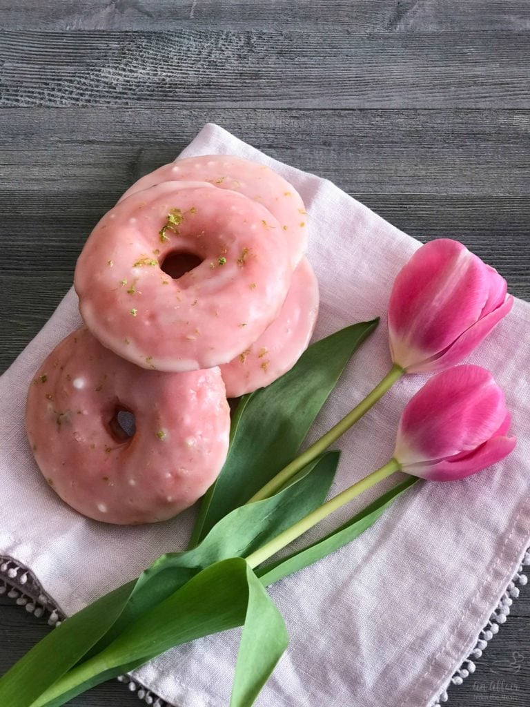 Overhead of Cherry Limeade Baked Donuts and tulips on a white cloth napkin