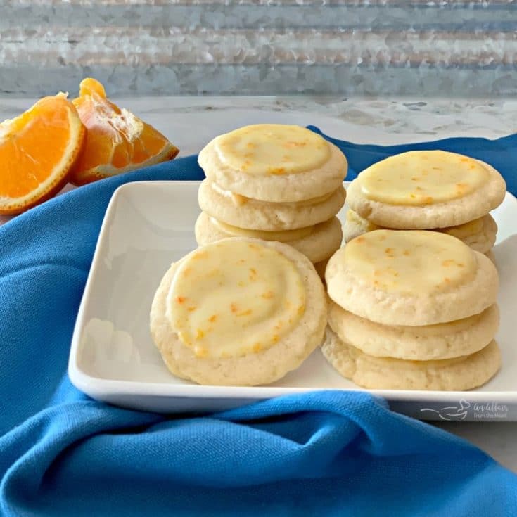 Orange Meltaway Cookies stacked on a white plate