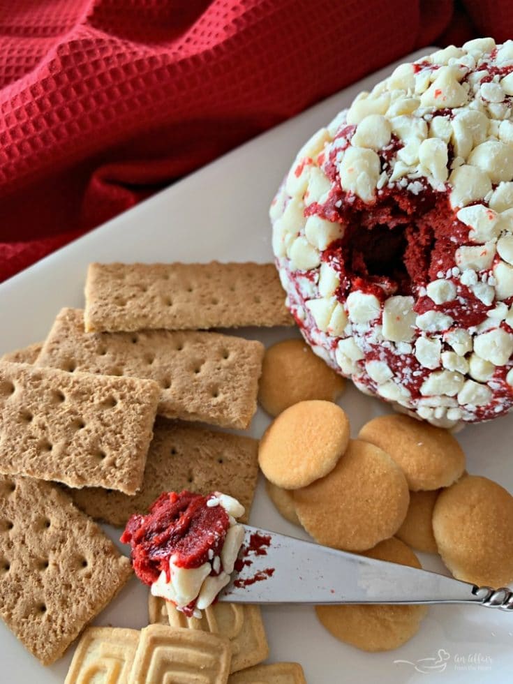 Red Velvet Cheese Ball on a white platter with cookie