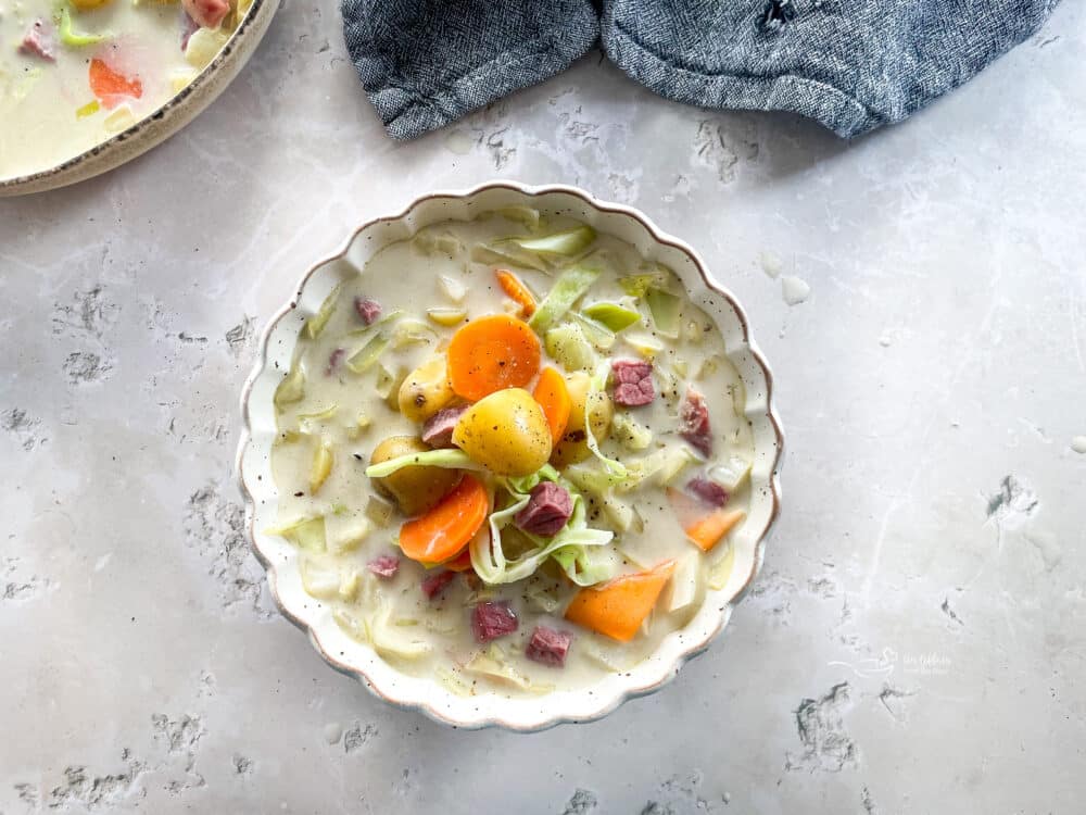 Creamy Corned Beef & Cabbage Soup in a white scalloped bowl