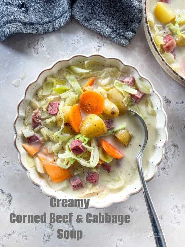 Creamy Corned Beef & Cabbage Soup in a white scallopped bowl with spoon