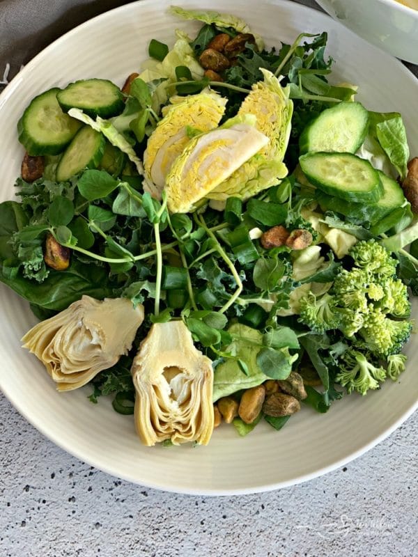 Overhead of Green Salad with Lemon Thyme Vinaigrette on a white plate