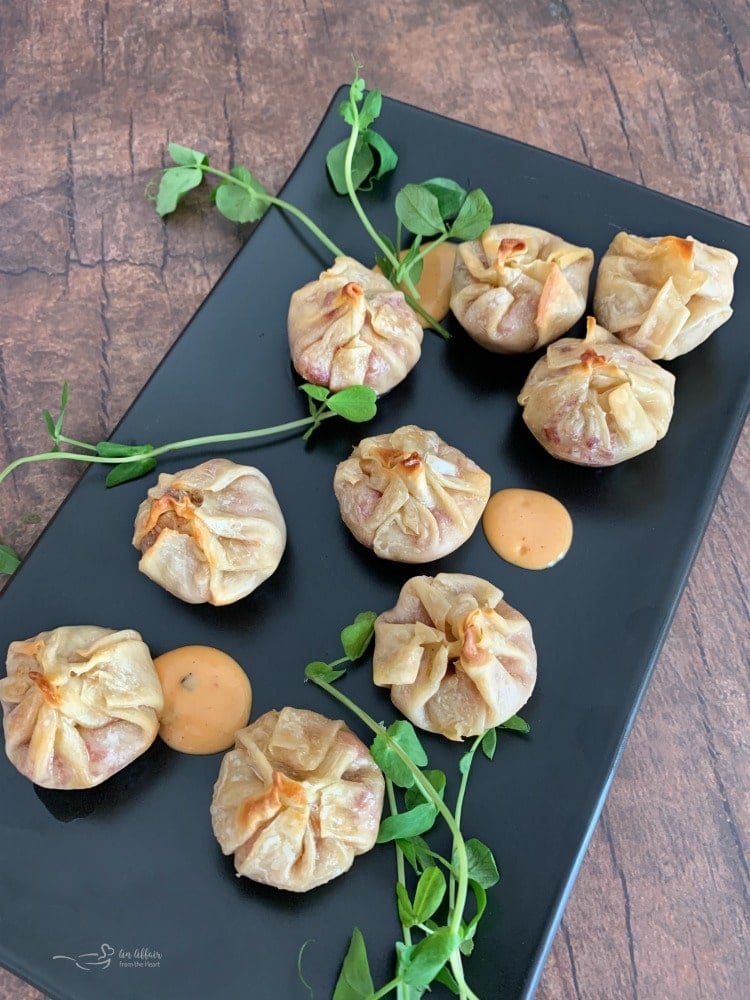 Overhead of Reuben Wonton Purses on a black serving plate