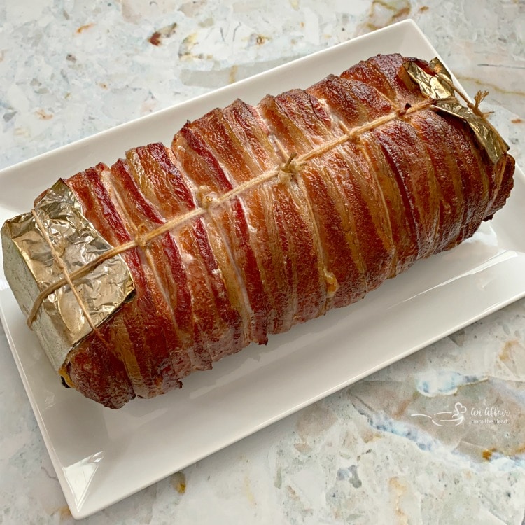 Bacon Wrapped Pork Tenderloin on white platter