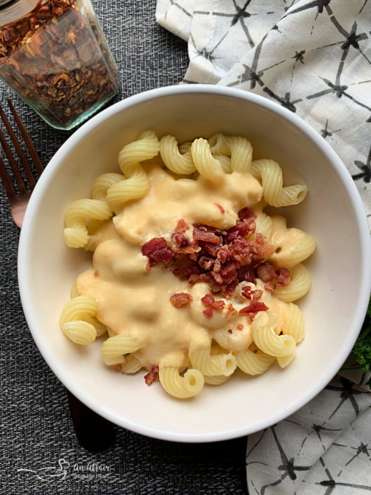 Overhead of Beer Cheese Pasta Sauce with bacon in a white bowl