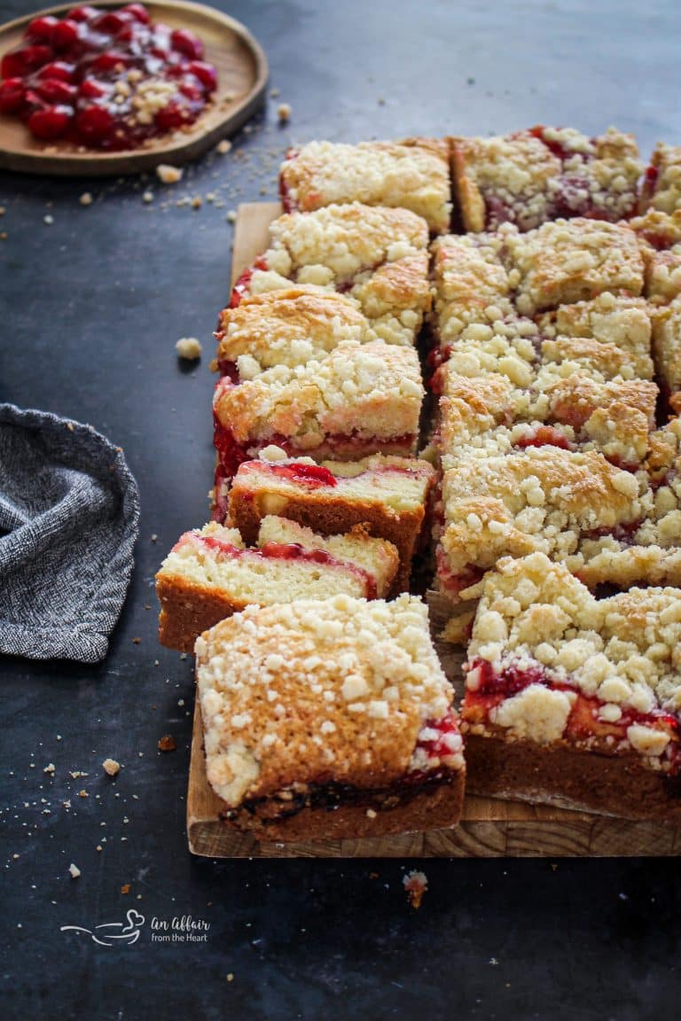 Close up, side view of Cherry filled coffee cake on a wooden board.