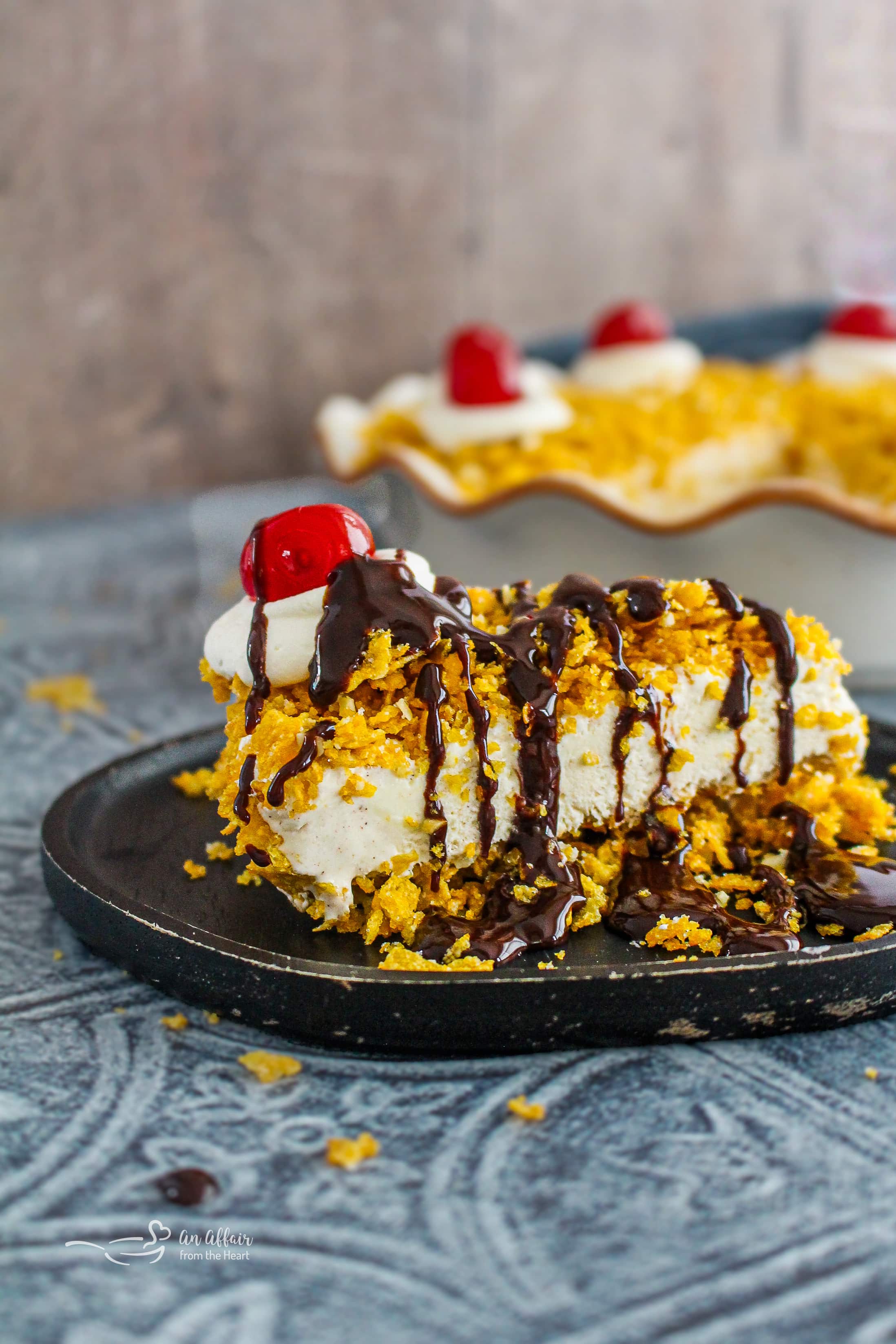 A Slice of Fried Ice Cream Pie topped with chocolate syrup, whipped cream and a cherry.