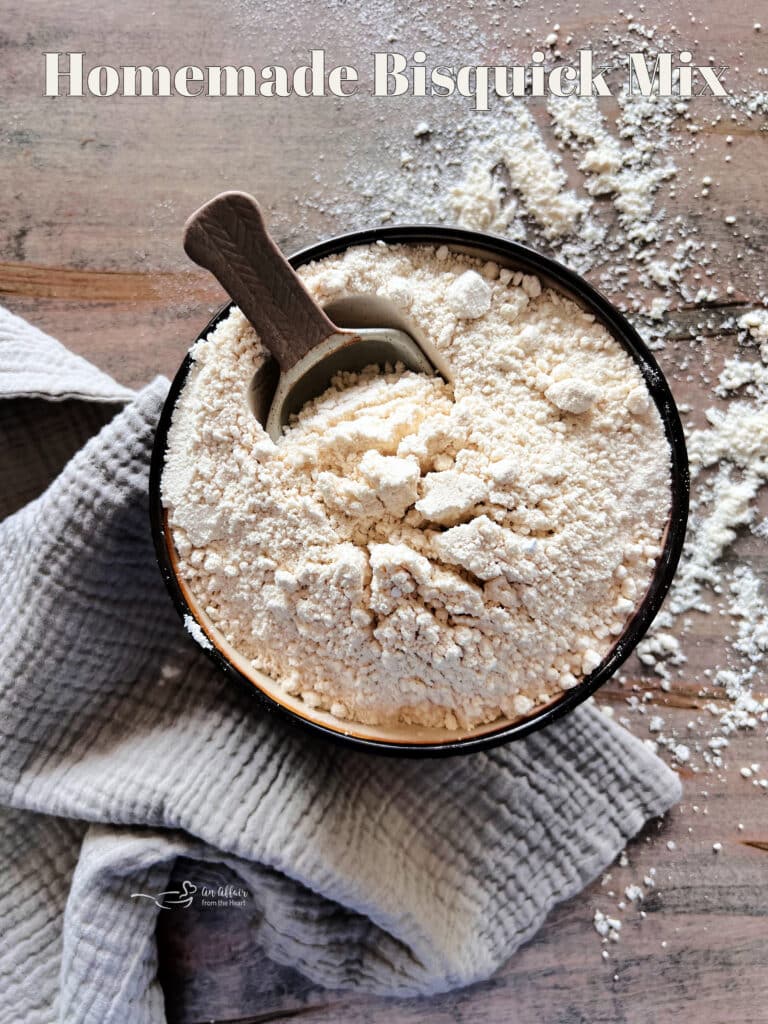 Homemade bisquick with a scoop in a dark colored bowl