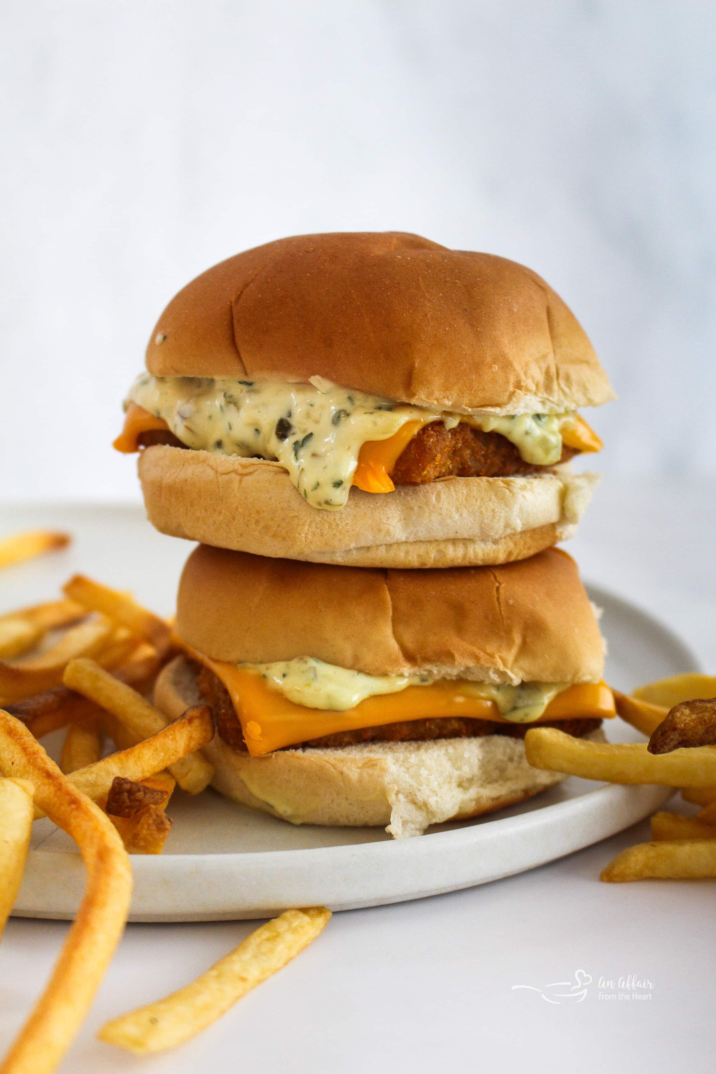 Two copycat McDonald's Filet o' Fish sandwiches stacked on a white plate.