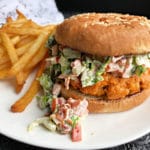 Blackened Salmon Burgers with BLT Slaw with fries on white plate