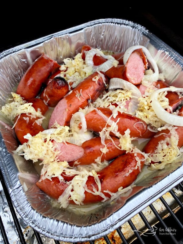 Grilled Polish Sausage and Sauerkraut in pan on grill