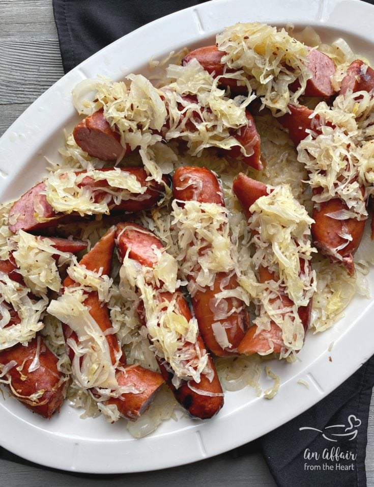 Top view of Grilled Polish Sausage and Sauerkraut white platter