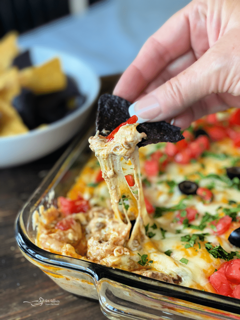 Dorothy's Hot Taco Dip with blue corn chip dipping