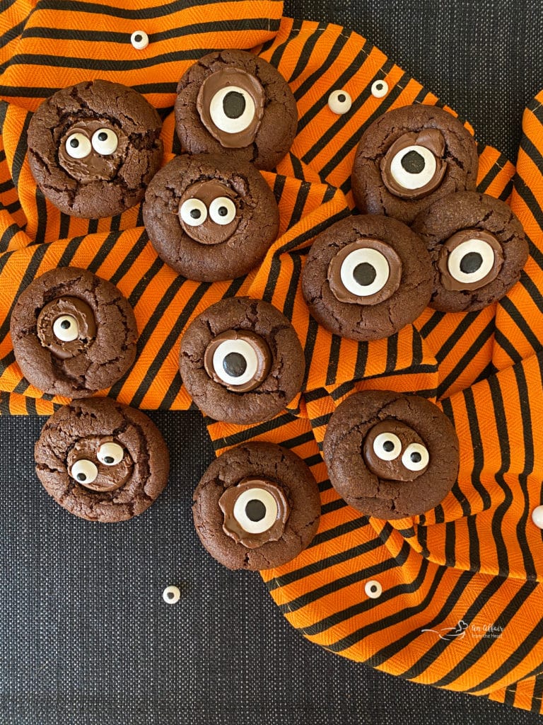 Overhead of Halloween Chocolate Sugar cookies on orange and black towel with eyes