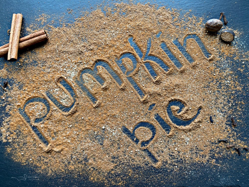 Spice poured out on a table with the word Pumpkin Pie written in it