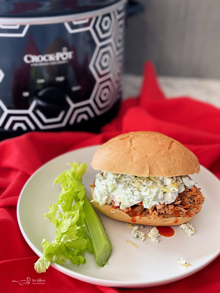 slow cooker buffalo pulled pork sandwich on white plate