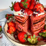 Close up of stacked Strawberry pancakes loaded with strawberries on top