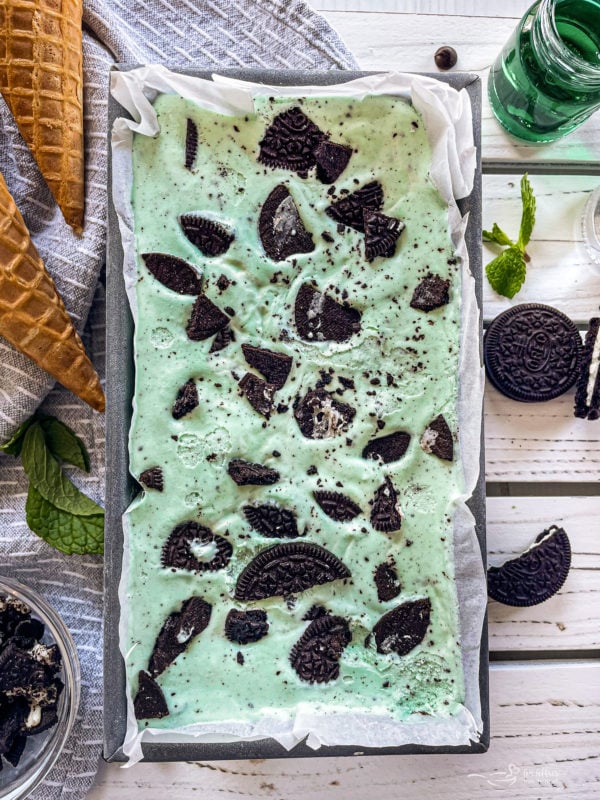 Top view of grasshopper pie ice cream in loaf pan with Oreos and fresh mint
