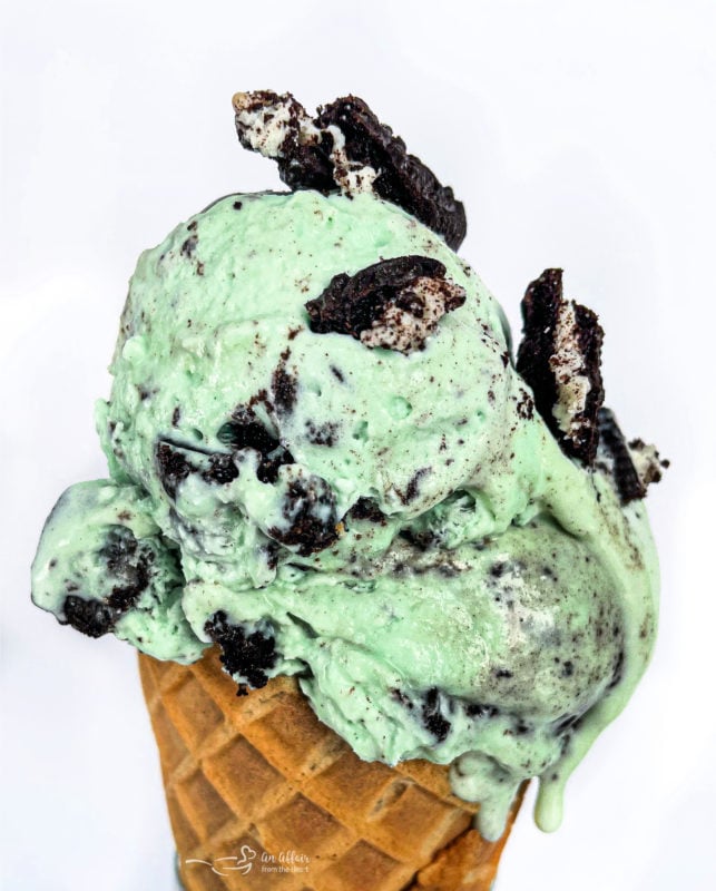 Front view of Grasshopper Pie Ice Cream in cone with chopped Oreo cookies