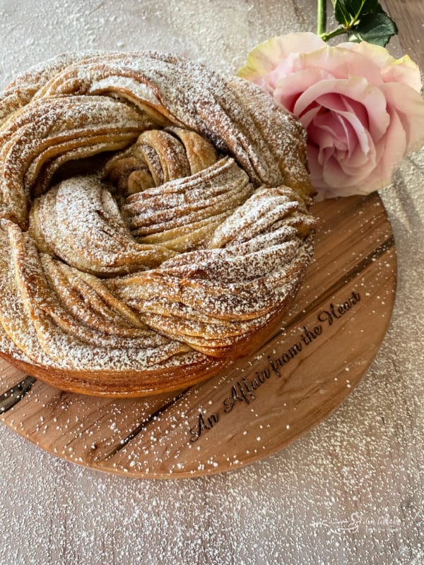 Russian rose bread with powdered sugar and pink rose