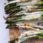 Top view of asparagus topped with melted cheeses