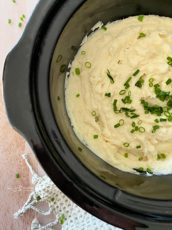 Top view of mashed potatoes in the Crockpot with chives