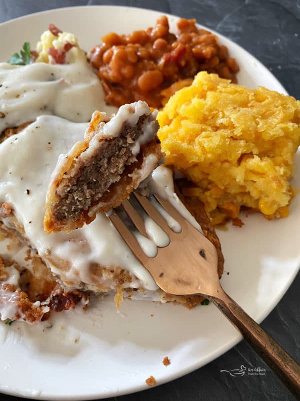 View of chicken patty on fork with gravy