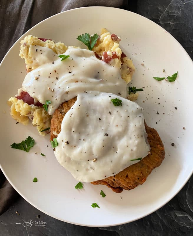 Top view of chicken patties and mashed potatoes with corn pie on white plate