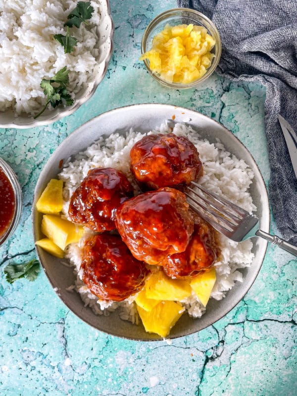 Top view of Hawaiian ham balls on plate with rice and pineapples