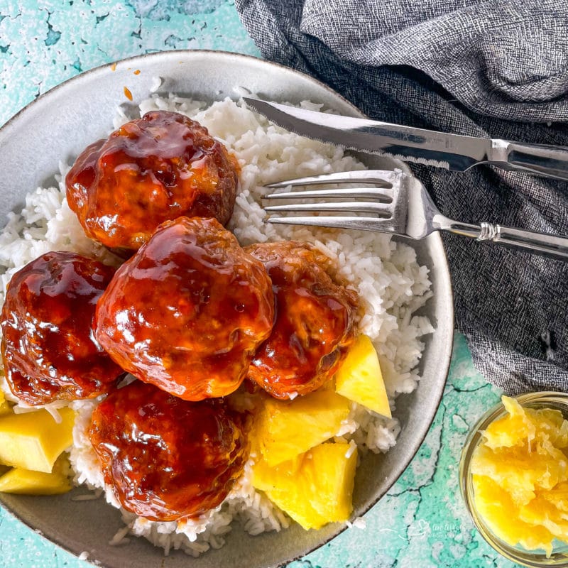 Top view of Hawaiian ham balls in bowl with pineapple chunks and rice