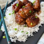 Sticky Asian Meatballs over rice on black plate