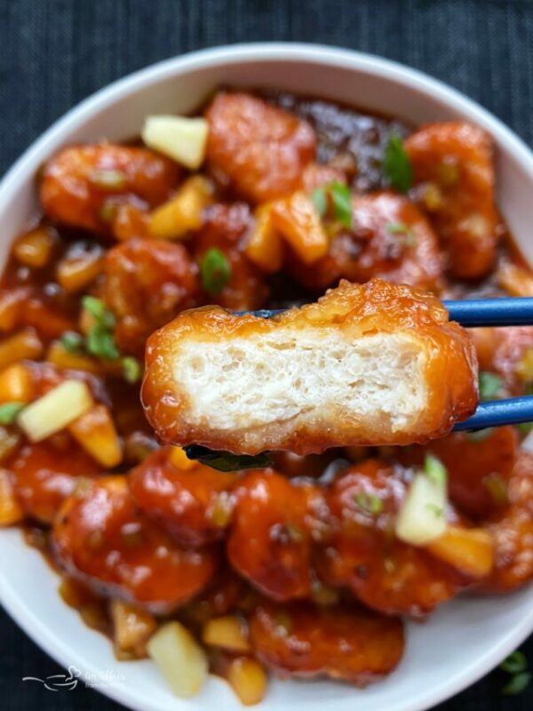 Close up of Sweet and sour chicken with a bite out of it.