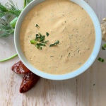 Chipotle Ranch dressing in a white bowl with a light wood background