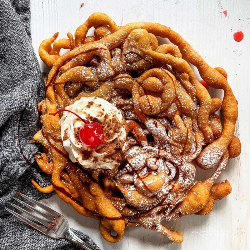 funnel cake with whipped cream and cherry