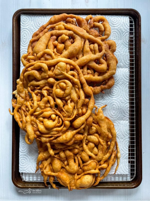 funnel cakes on paper towel with baking sheet