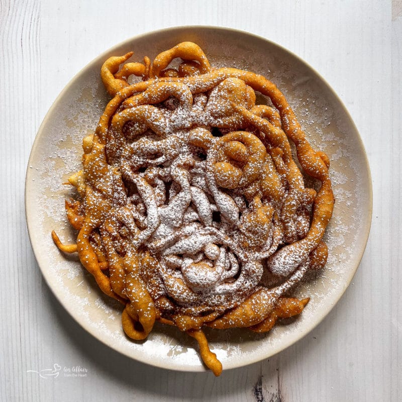 funnel cakes on plate with powdered sugar
