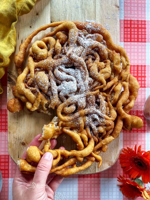 piece of funnel cake being pulled 